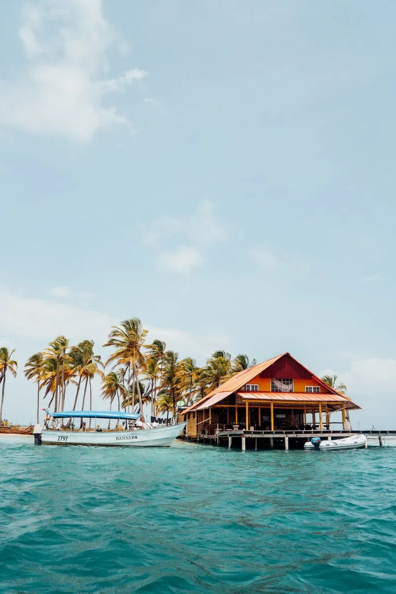 Île couverte de palmiers et lodge entourés par les eaux des Caraïbes à San Blas