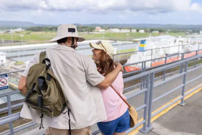 Visitantes que miran al otro lado del Canal de Panamá desde una plataforma de observación