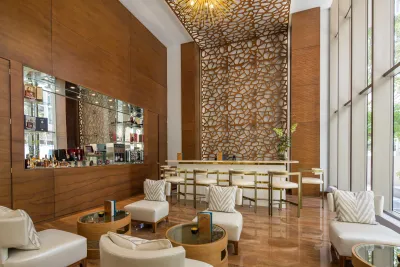 Peacock Alley lobby bar at Waldorf Astoria Panama, with warm wood walls and the signature gold honeycomb screen