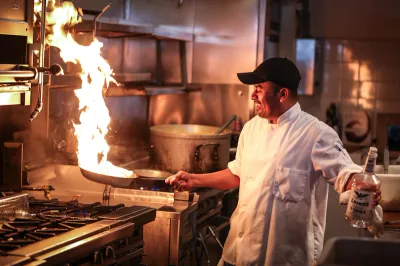 Private chef cooking with flames in a professional kitchen