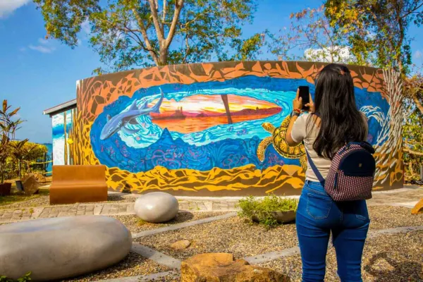 Visitor photographing a sea-life mural at Punta Culebra Nature Center