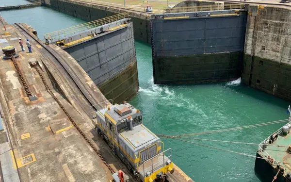 Miraflores lock gates with mula locomotive guiding a ship through