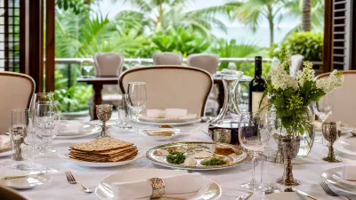 Elegante mesa del seder de Pesaj con vistas a la vegetación tropical