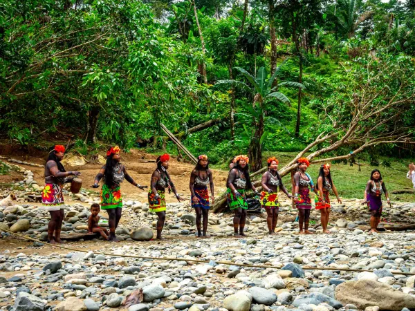 Embera community welcoming visitors at the riverbank in traditional dress