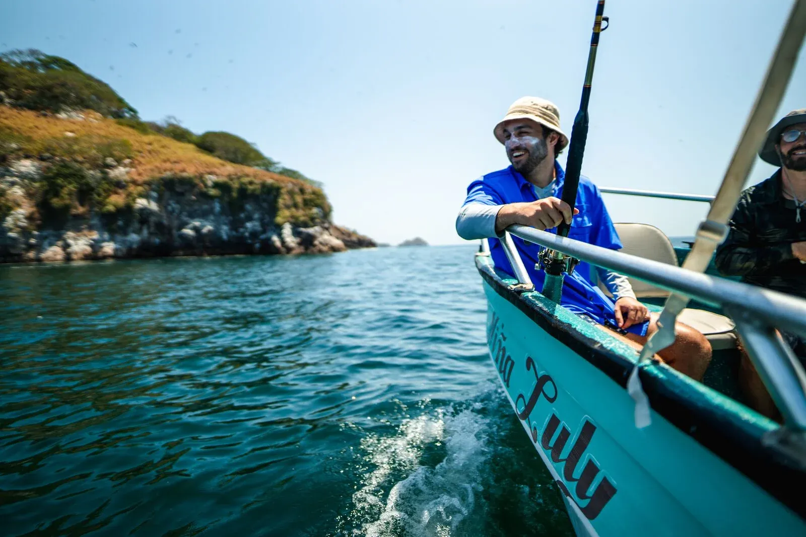 Angler on an inshore boat near a rocky island in Panama Bay