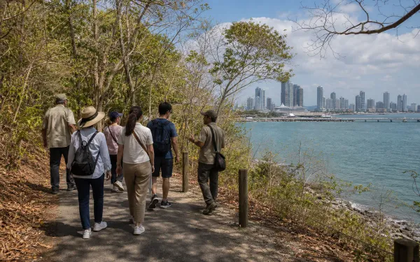 Visitors walking the coastal dry forest path at Punta Culebra with Panama Bay views