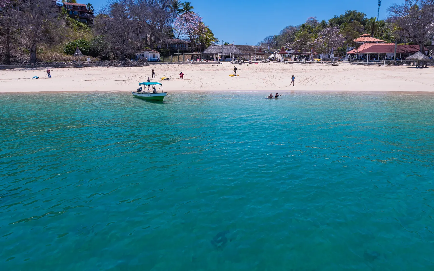 Boats moored in calm water off Cacique Beach on Contadora Island